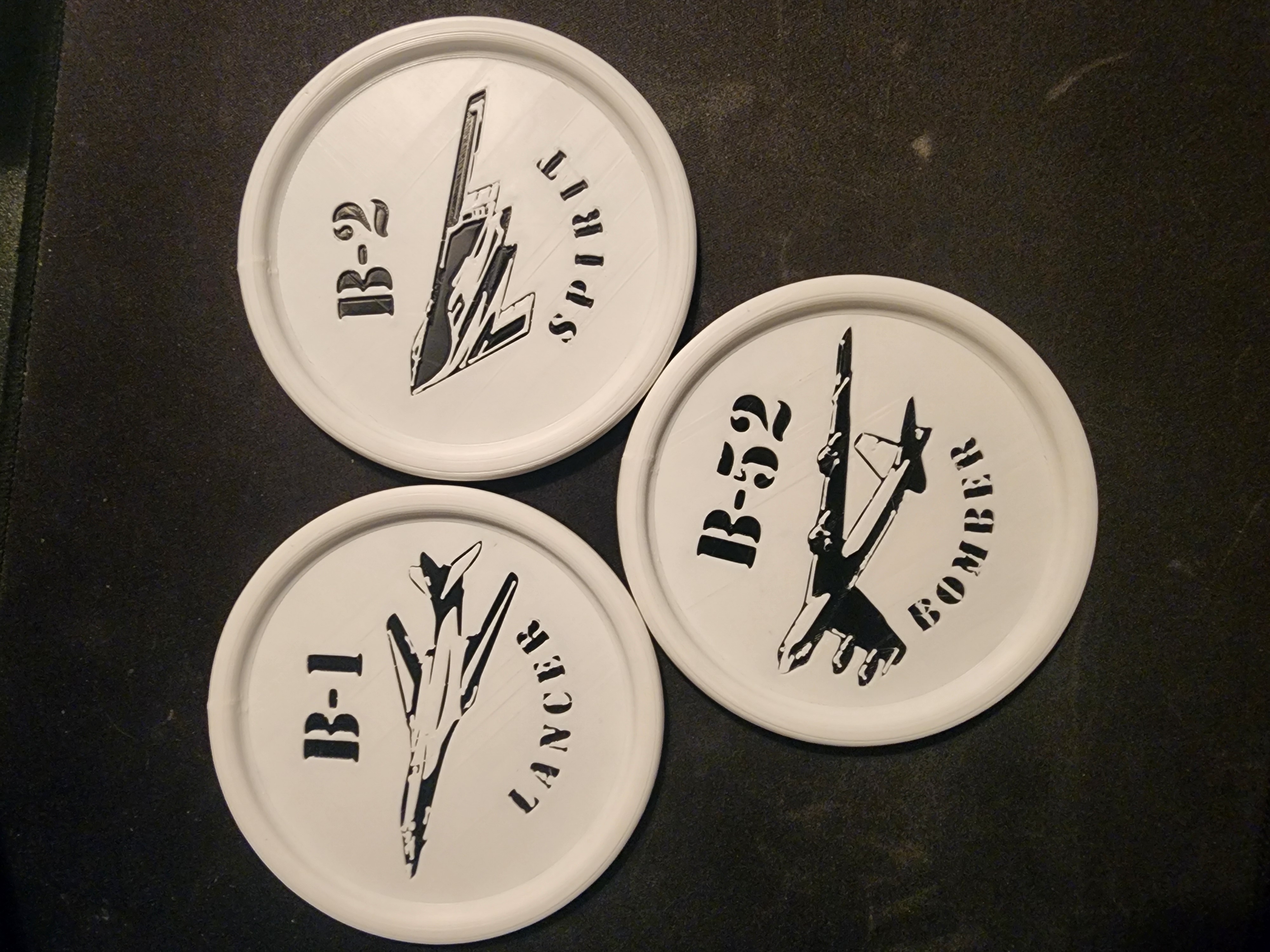 Three white aviation-themed coasters labeled B-1, B-2, and B-52